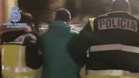 Dos agentes de la Policía Nacional con el fugitivo detenido en Barcelona / POLICÍA NACIONAL