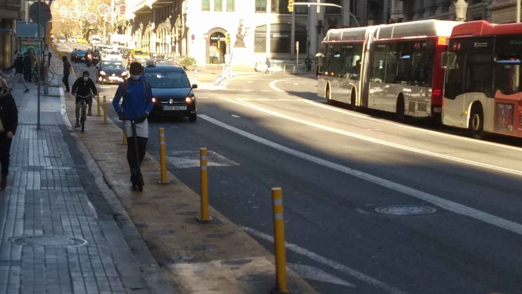 Un patinete y una bici en el carril peatonal de vía Laietana / MA - JORDI SUBIRANA