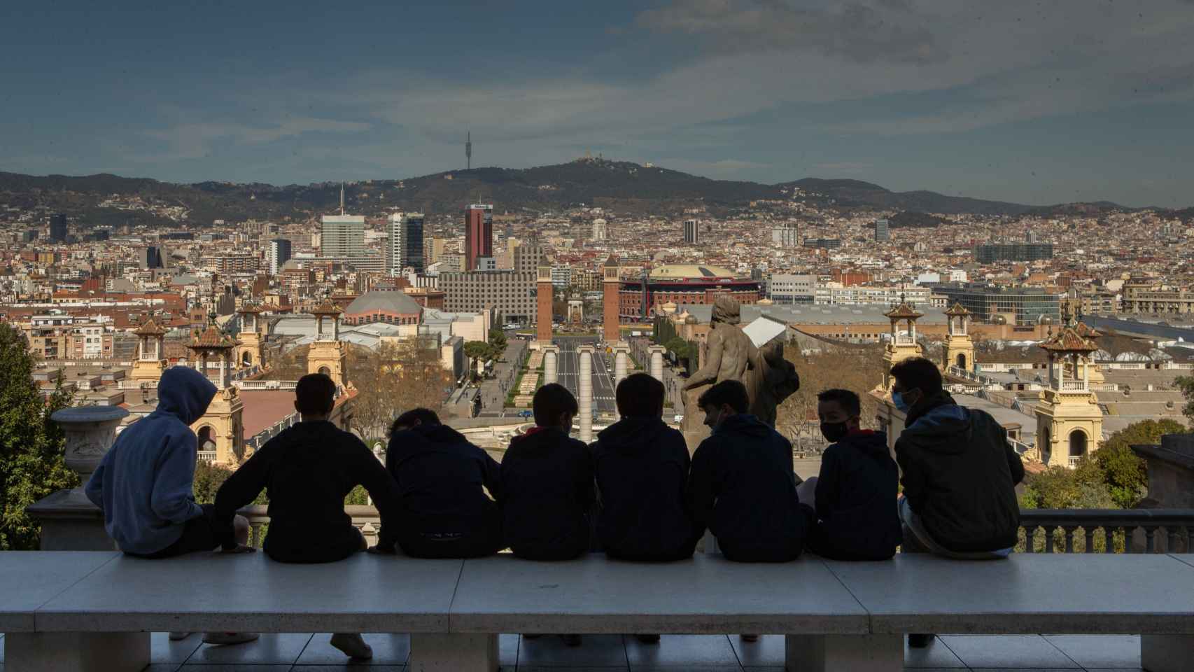 Un grupo de jóvenes observa Barcelona desde la entrada principal del MNAC / EFE - Enric Fontcuberta