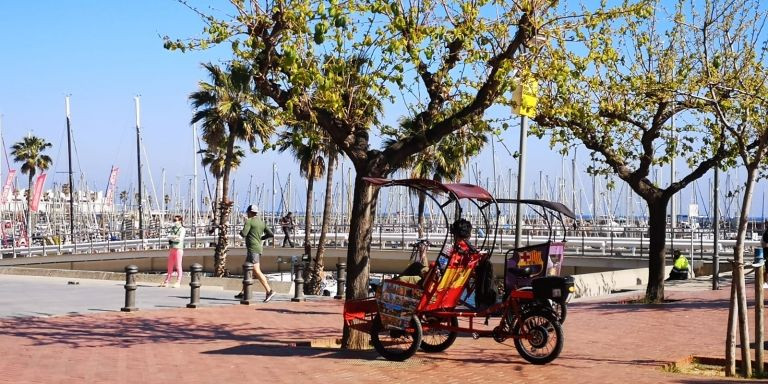 Una 'bicitaxi' espera la llegada de clientes en el Port Olímpic este martes / GUILLEM ANDRÉS