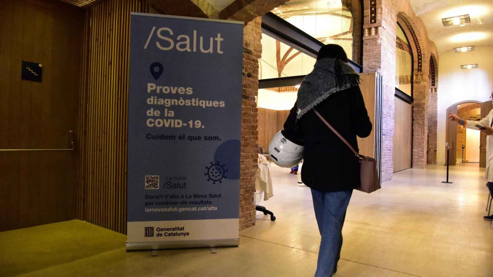 Una joven entra en un edificio de Barcelona donde realizan pruebas diagnósticas del Covid-19 / EUROPA PRESS