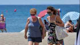 Dos mujeres con mascarilla en la playa / EFE - CARLOS BARBA