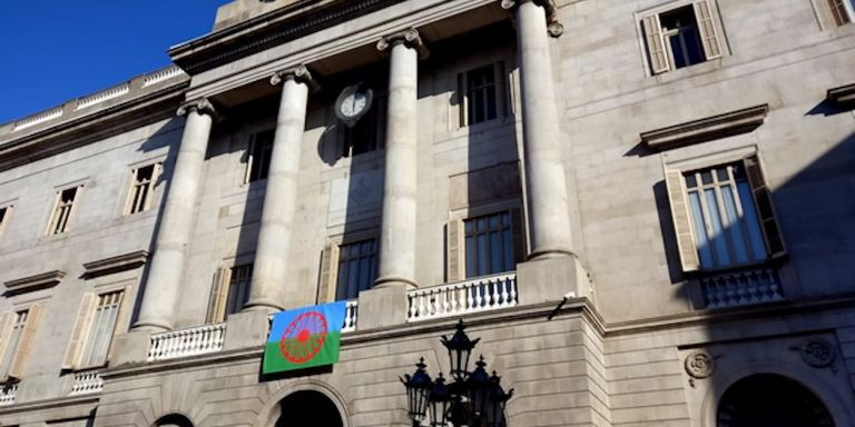 La bandera del pueblo gitano o romaní, luciendo en la fachada del Ayuntamiento de Barcelona / AJ BCN