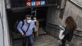 Usuarios con mascarilla salen del metro en Collblanc / EUROPA PRESS