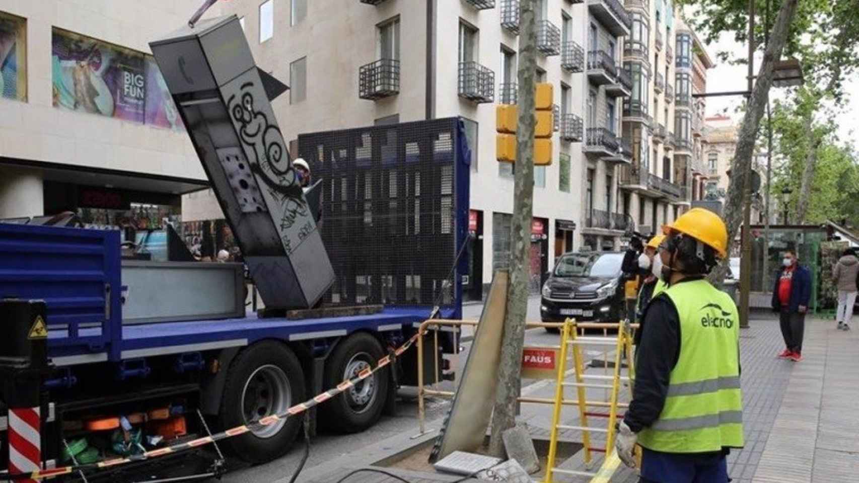 Operarios retiran las cabinas telefónicas de La Rambla de Barcelona / AMICS DE LA RAMBLA