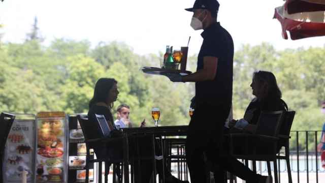 Un camarero protegido con mascarilla atiende a una mesa de una terrazas / Europa Press