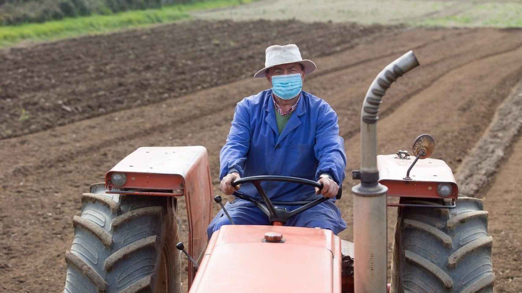 Un agricultor con mascarilla conduce un tractor en una imagen de archivo / EUROPA PRESS