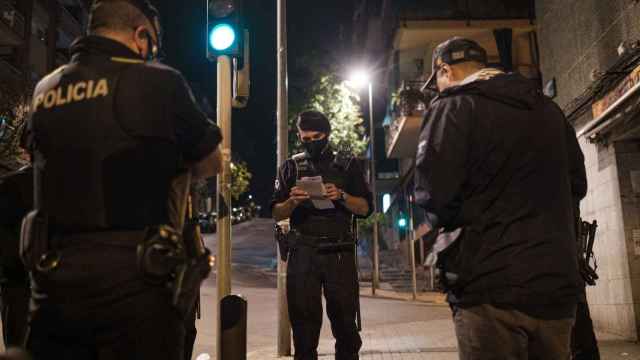 Agentes de la Omega, unidad antidisturbios, identifican a dos hombres que incumplían el toque de queda nocturno en Badalona / PABLO MIRANZO