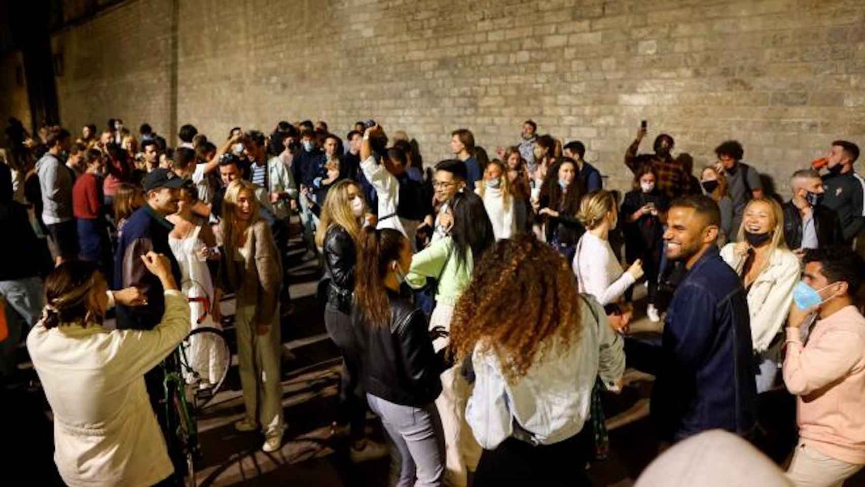 Jóvenes de fiesta en el Fossar de les Moreres (El Born) tras el levantamiento del toque de queda / EFE