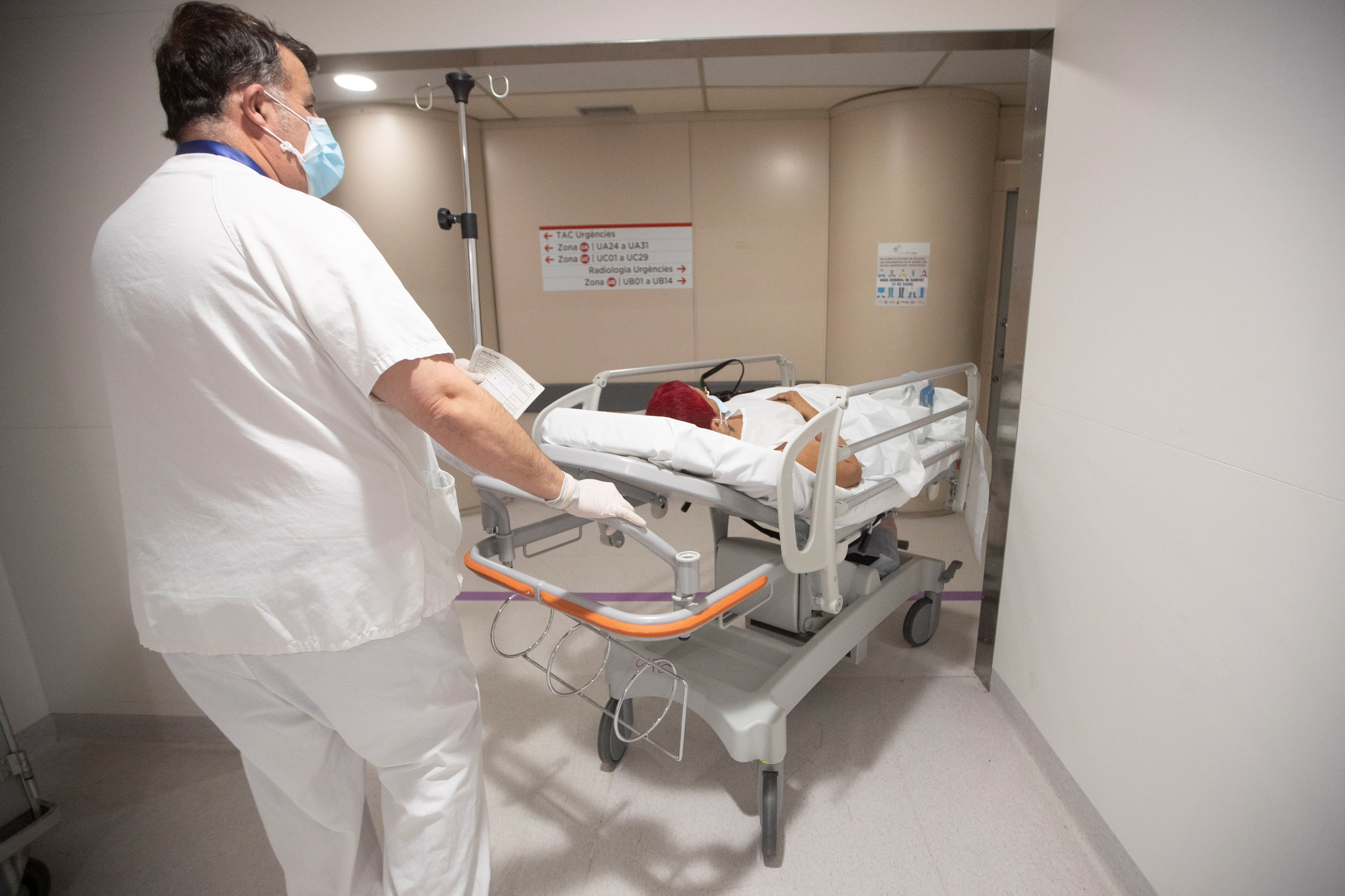 Un trabajador del Hospital del Vall d'Hebron de Barcelona empuja una camilla / EFE - MARTA PÉREZ