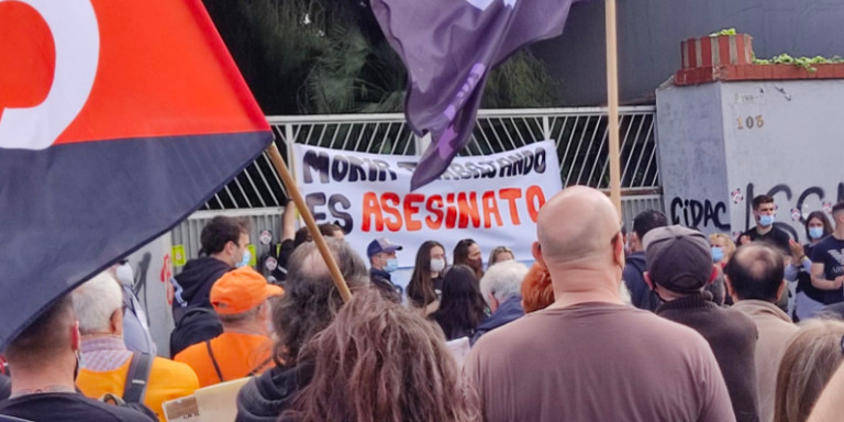 Manifestantes junto a la pancarta con el lema morir trabajando es asesinato en la manifestación / CGT