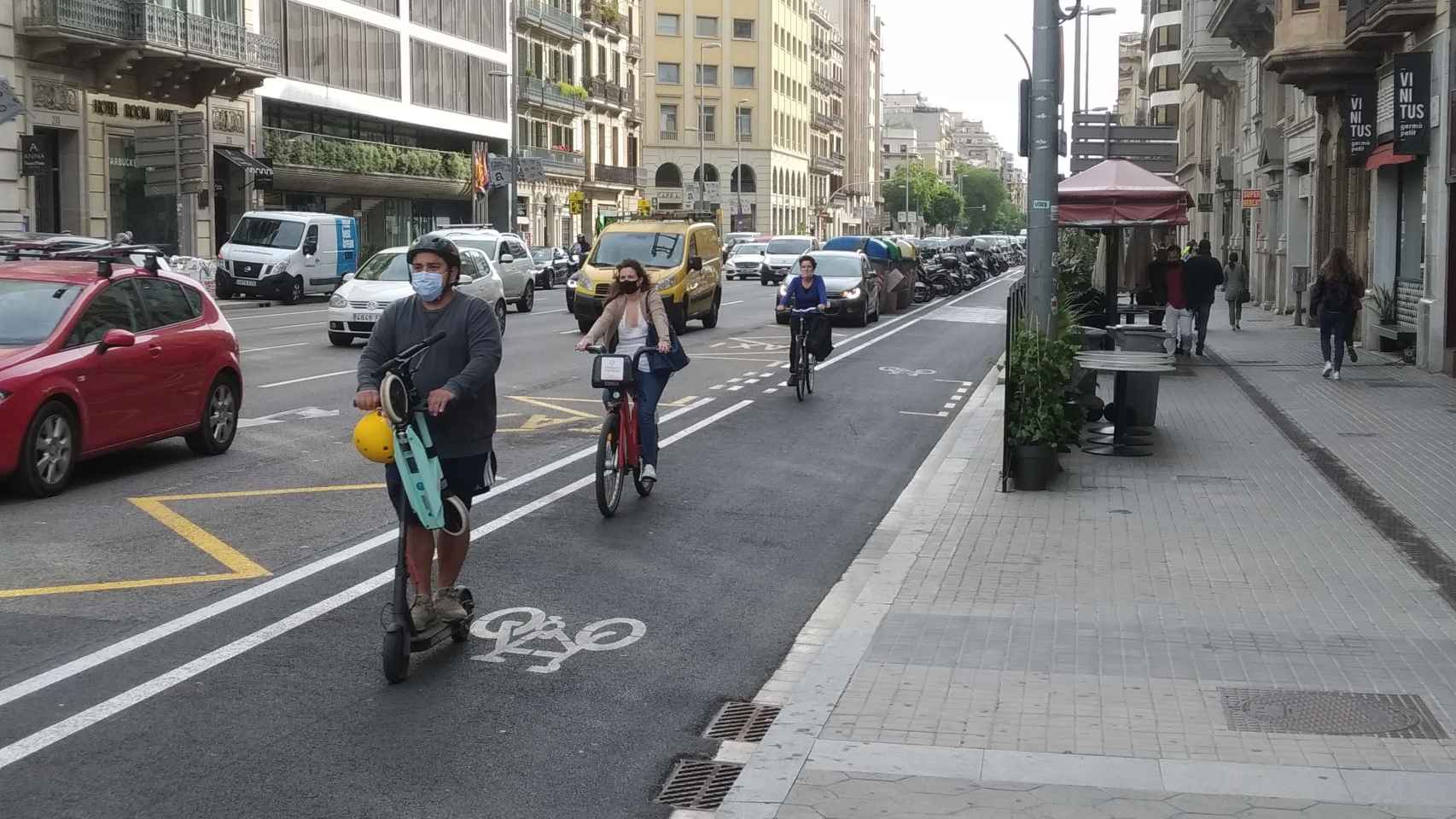Usuarios en patinete y bicicleta en el carril bici de Aragó, a la altura del paseo de Gràcia / METRÓPOLI - JORDI SUBIRANA