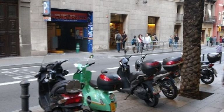 Motos en la acera, delante del parking subterráneo para motos de Gràcia / METRÓPOLI - JS