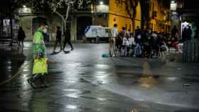 Un hombre riega una calle de Barcelona, una semana después del fin del estado de alarma, en Barcelona / Kike Rincón - Europa Press