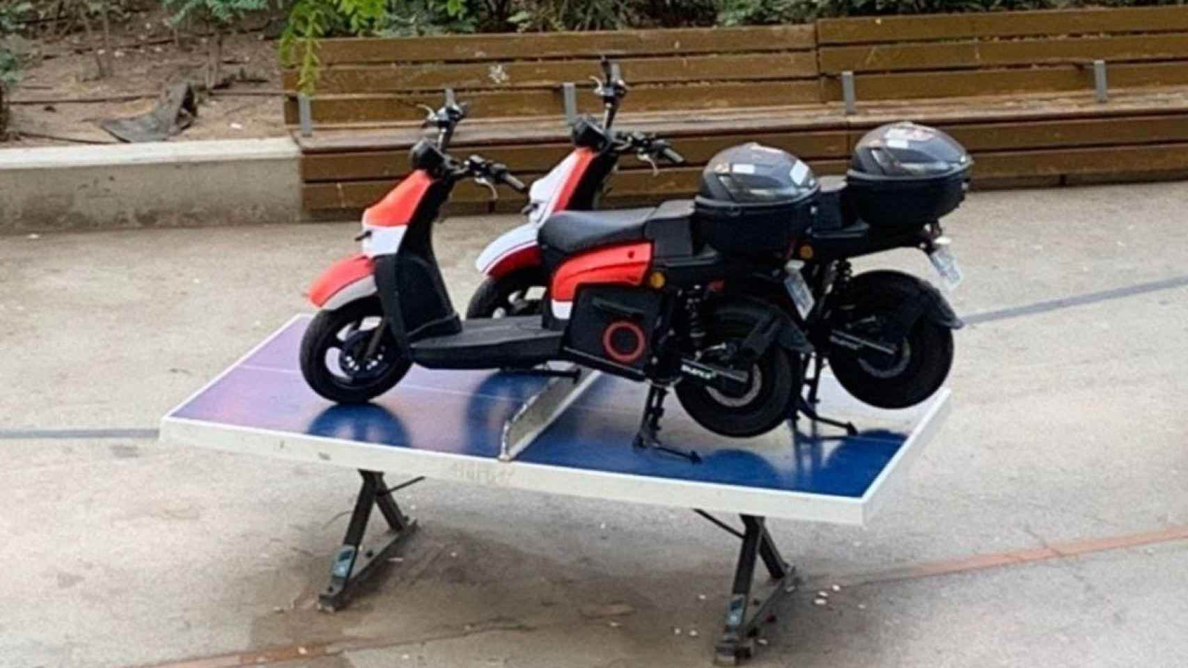 Dos motos de la empresa Acciona en una mesa de pimpón de la plaza de la Gal·la Placídia / TELEGRAM