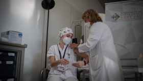 Una enfermera vacuna a un profesional sanitario con la vacuna de Pfizer-BioNtech contra el COVID-19 en el Hospital de la Santa Creu i Sant Pau de Barcelona / David Zorrakino