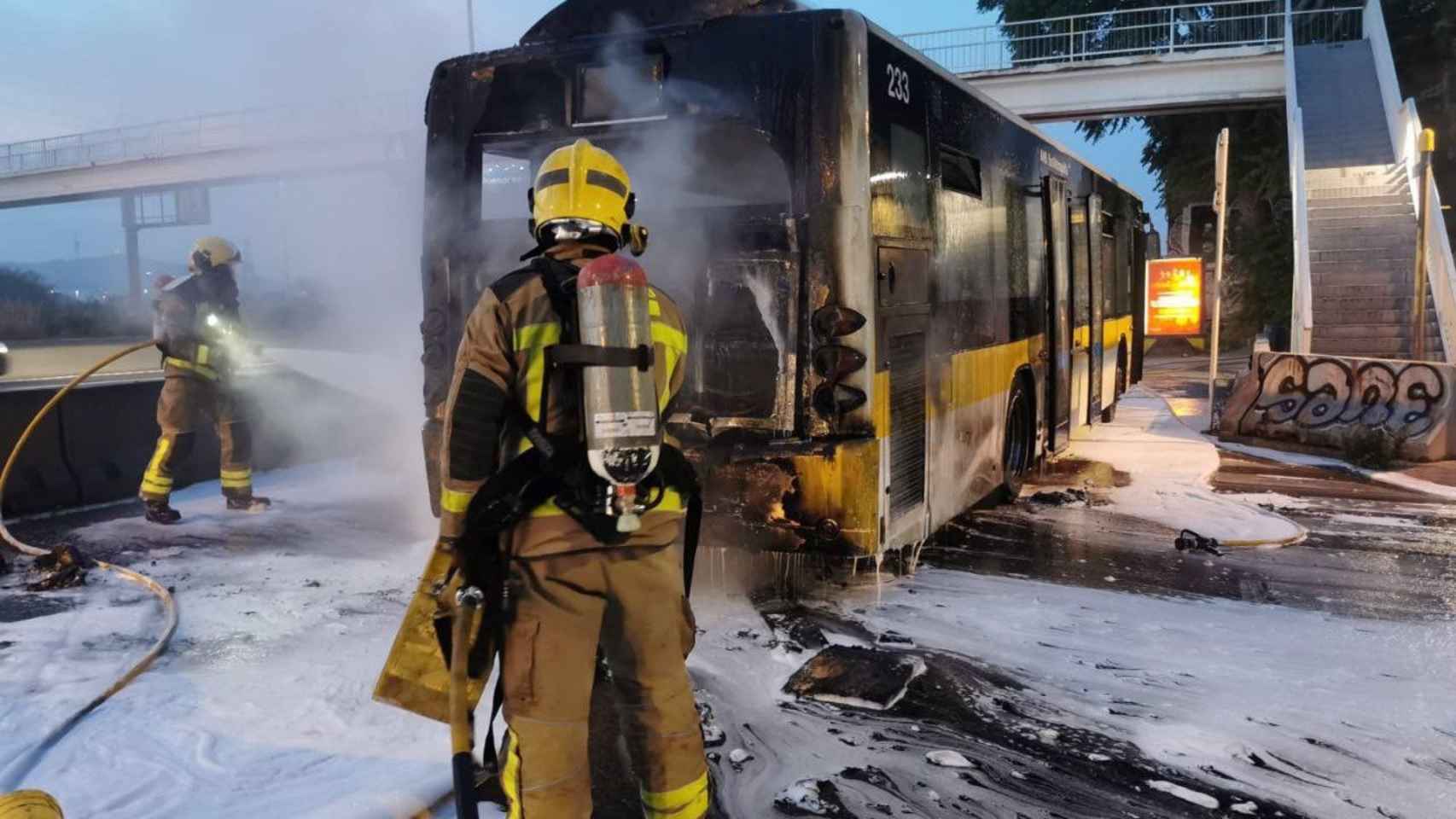 Un bombero sofoca las llamas con espuma del autobús incendiado en la C-3 / BOMBERS DE LA GENERALITAT