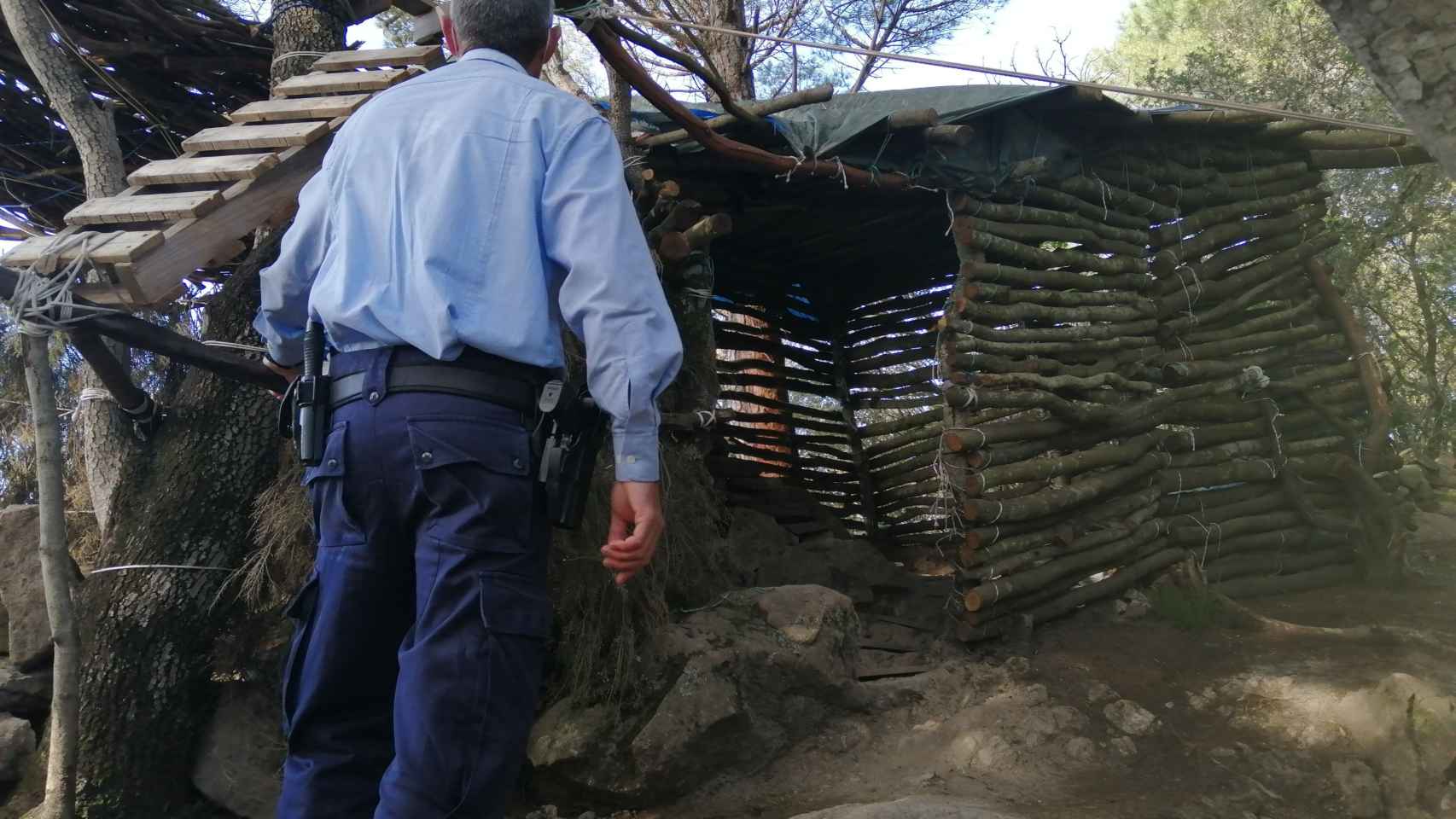 Un agente de la URMA tras descubrir las cabañas en el parque del Montnegre i Corredor / MOSSOS D'ESQUADRA