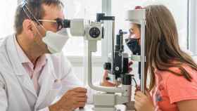 El oftalmólogo y cirujano del Hospital Sant Joan de Déu Jaume Català junto a la menor de 12 años que nació con una distrofia hereditaria de la retina que han