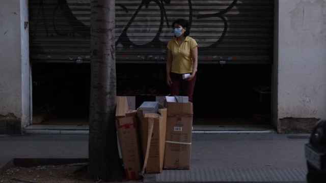 Una mujer observa la acumulación de basura enfrente de su establecimiento de Sant Andreu / PABLO MIRANZO
