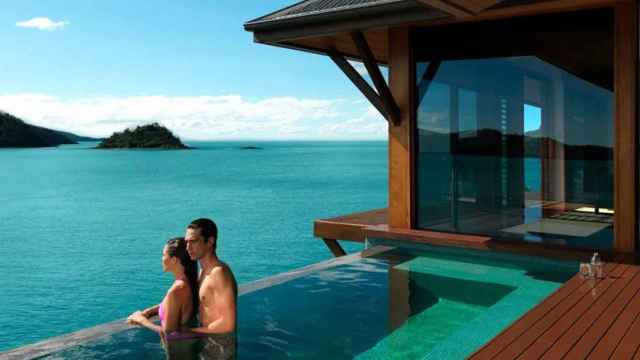 Una pareja en una piscina frente al mar