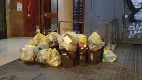 Bolsas de basura y cubos de materia orgánicos, amontonados en la portería de una finca / AV Sant Andreu Sud