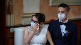 Una pareja se casa con la mascarilla puesta durante la pandemia del covid-19 / EFE
