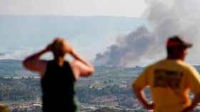 Dos personas observan un incendio forestal en Cataluña / EFE