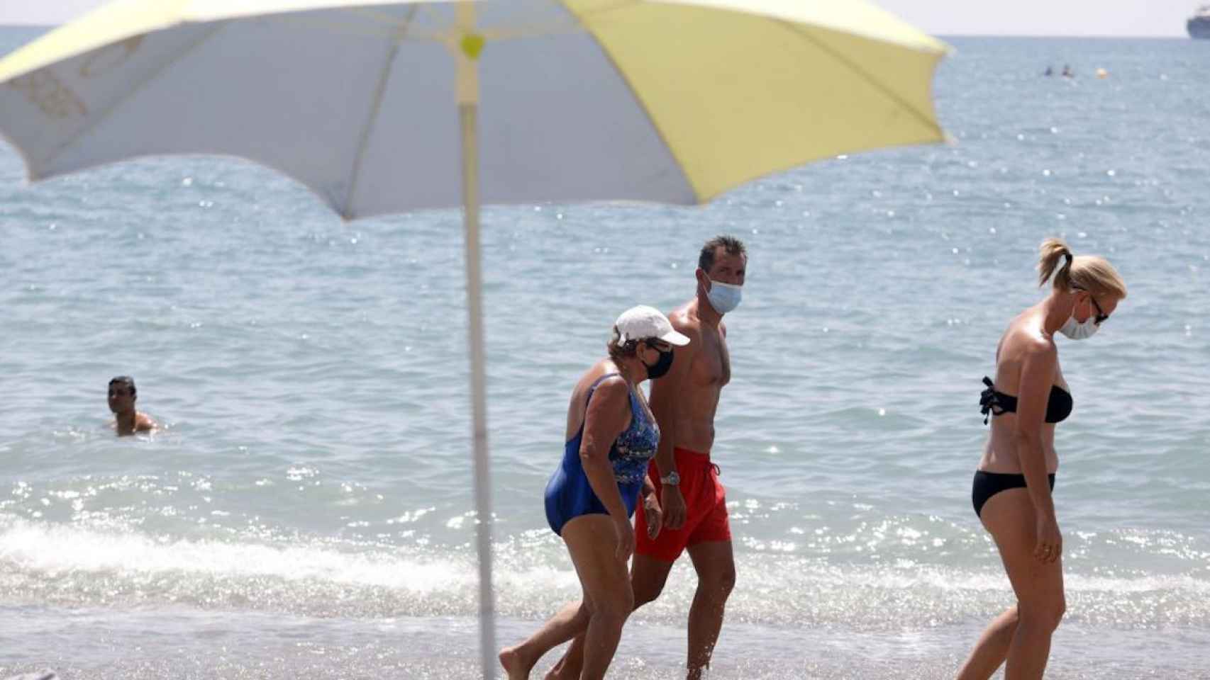 Bañistas combaten el calor en la playa y sin quitarse la mascarilla / EUROPA PRESS