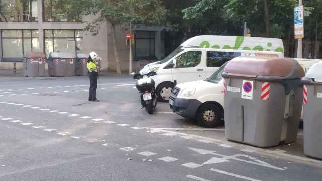 Una vigilante de los parquímetros denuncia a vehículos aparcados en una zona de carga y descarga en el Eixample / METRÓPOLI - JORDI SUBIRANA