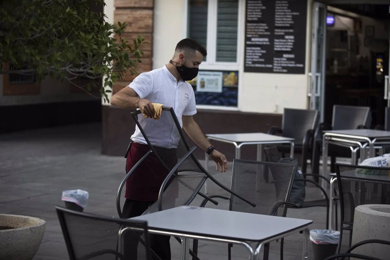 Un camarero recoge el mobiliario de la terraza de un bar / Europa Press