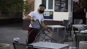 Un camarero recoge el mobiliario de la terraza de un bar / María José López | Europa Press