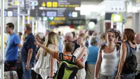 Imagen de turistas en el aeropuerto de El Prat esperano la salida de su vuelo