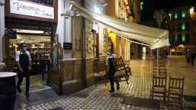 Dos camareros recogen la terraza de un bar de Barcelona antes del toque de queda / EUROPA PRESS