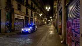 Una patrulla de la Guardia Urbana recorre la Calle Ferran de Barcelona durante la aplicación del “toque de queda” / EFE - Enric Fontcuberta.