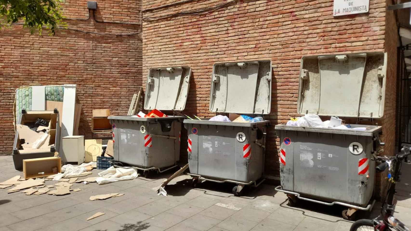 Contenedores llenos de suciedad y objetos en la calle de la Maquinista de la Barceloneta / METRÓPOLI