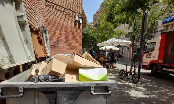 Contenedores llenos de suciedad y objetos al lado de una terraza en la calle de la Maquinista / METRÓPOLI