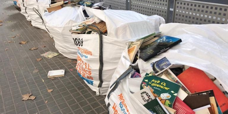 Decenas de libros, dentro de sacos de escombros, delante de una escuela del Eixample / CEDIDA