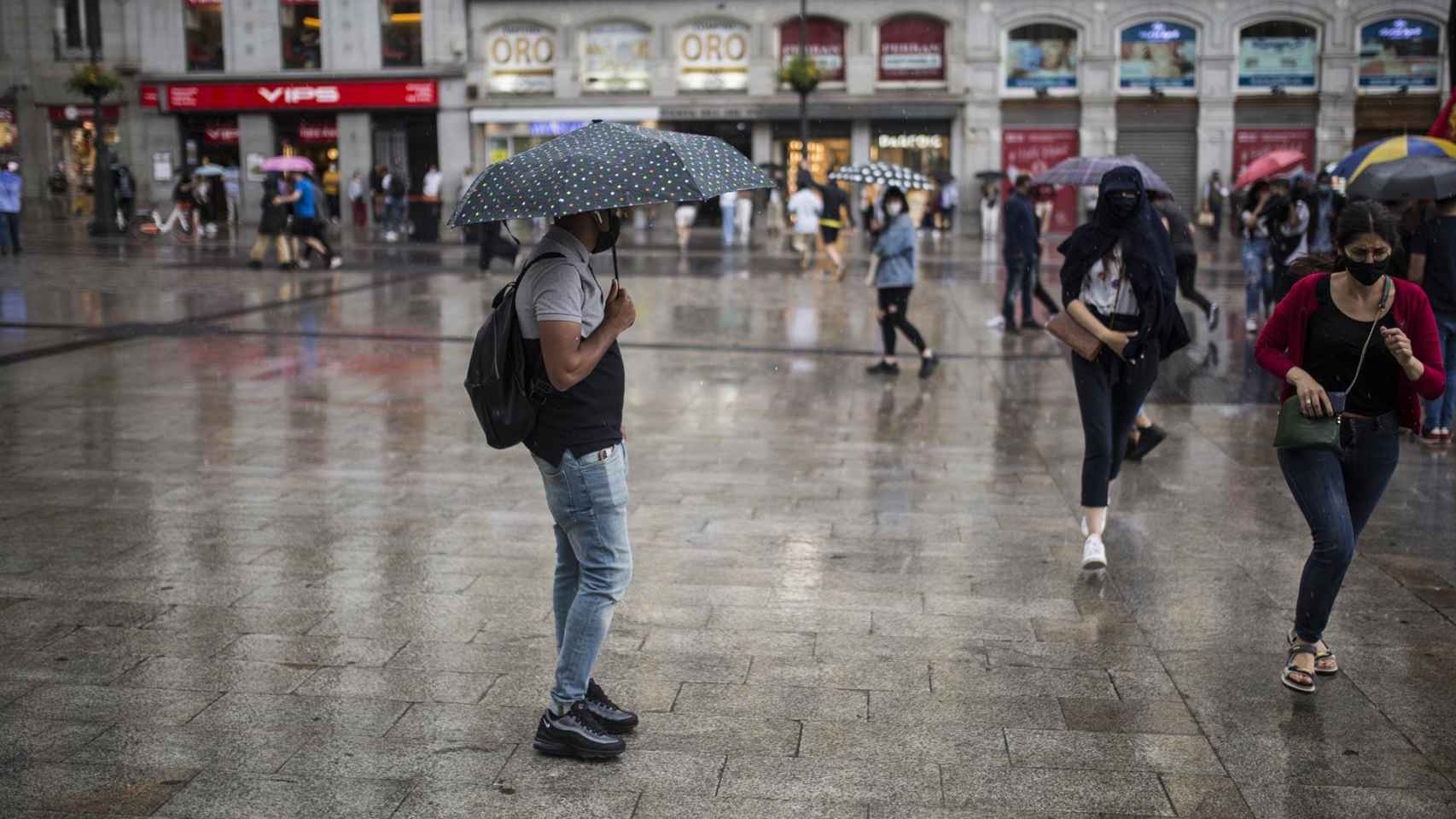 Ciudadanos resguardándose de la lluvia durante una manifestación en Madrid / Alejandro Martínez Vélez - Europa Press