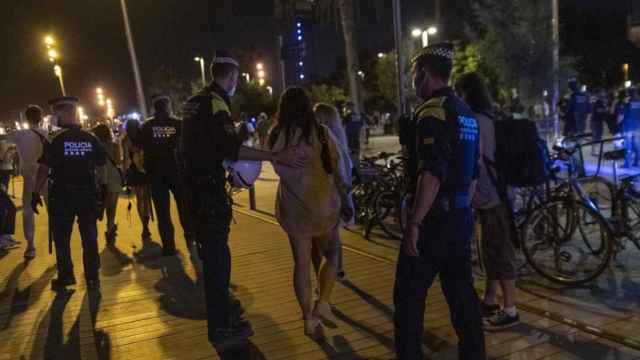 Varios agentes informan en Barcelona de que quedan pocos minutos para el inicio del toque de queda en una imagen de archivo / EFE