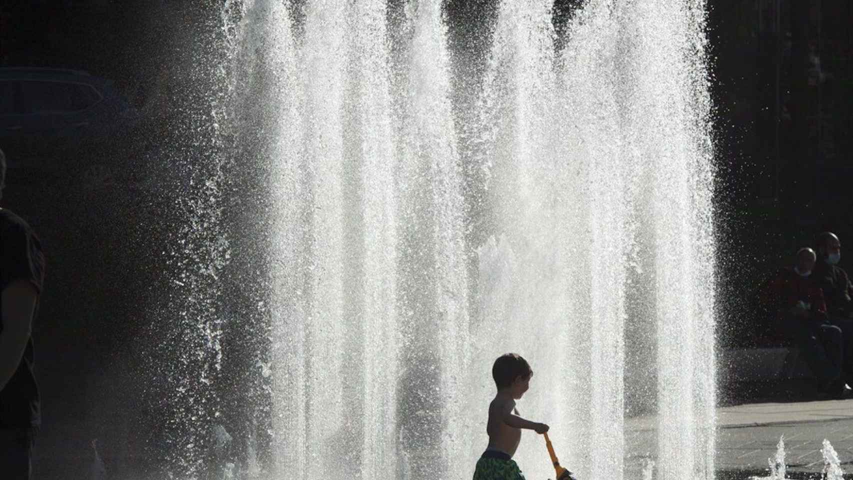 Un niño se refresca contra el calor en una fuente / EUROPA PRESS