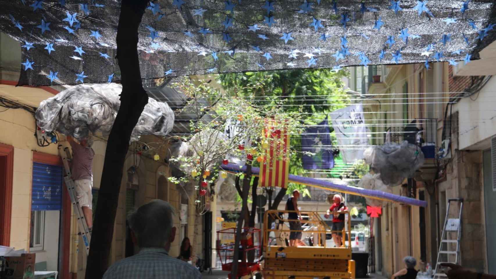 Montaje de la decoración de una calle de la Vil·la de Gràcia este viernes / JORDI CUIXART