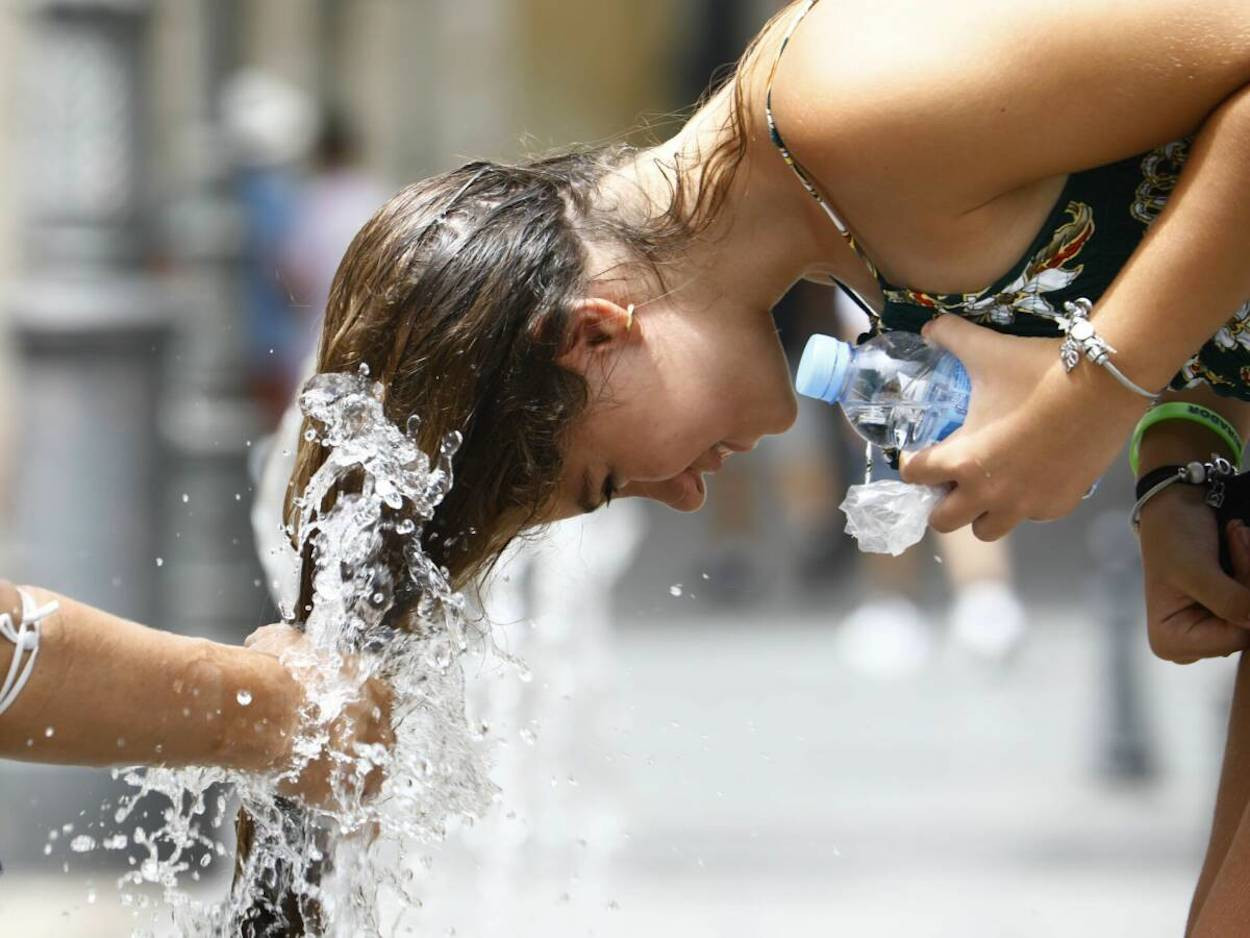 Una joven se remoja el pelo durante la ola de calor / EFE
