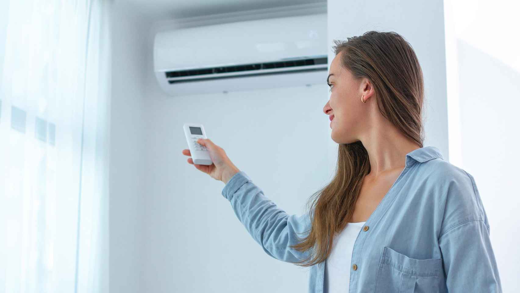 Una mujer enciende un aparato de aire acondicionado / ENDESA