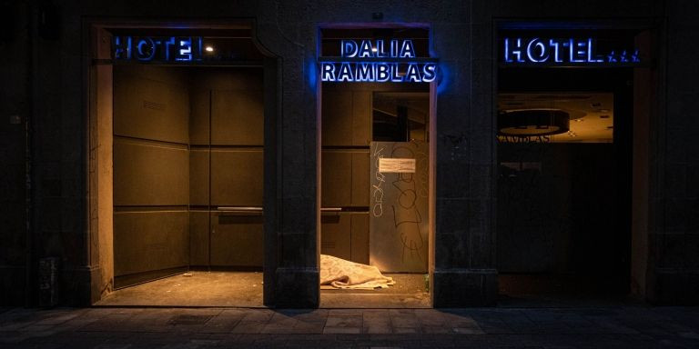 Una persona sintecho durmiendo en la entrada de un hotel de la Rambla / PABLO MIRANZO - MA