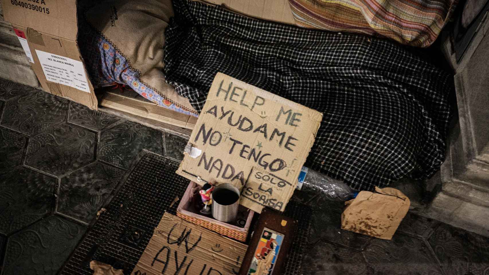 Carteles de ayuda de uno de los sintecho que duermen en las calles de Barcelona / PABLO MIRANZO - MA
