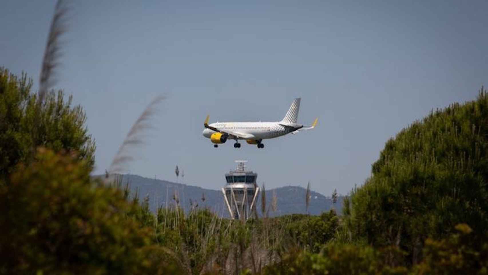 Un avión sobrevuela el paraje de La Ricarda, junto al aeropuerto de El Prat / EUROPA PRESS -DAVID ZORRAKINO