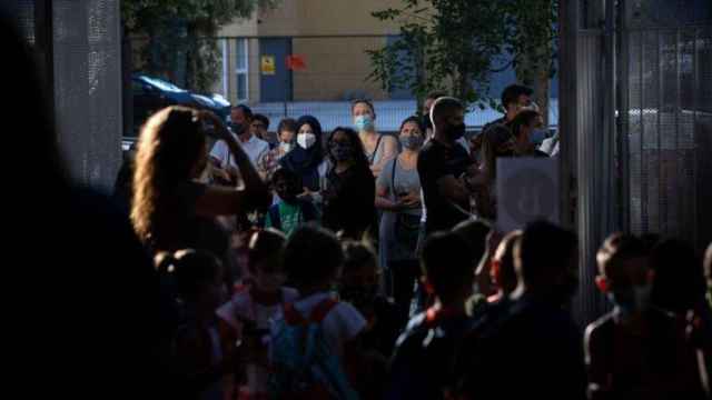 Padres y escolares esperan a las puertas de un colegio protegidos contra el Covid con mascarillas / EP