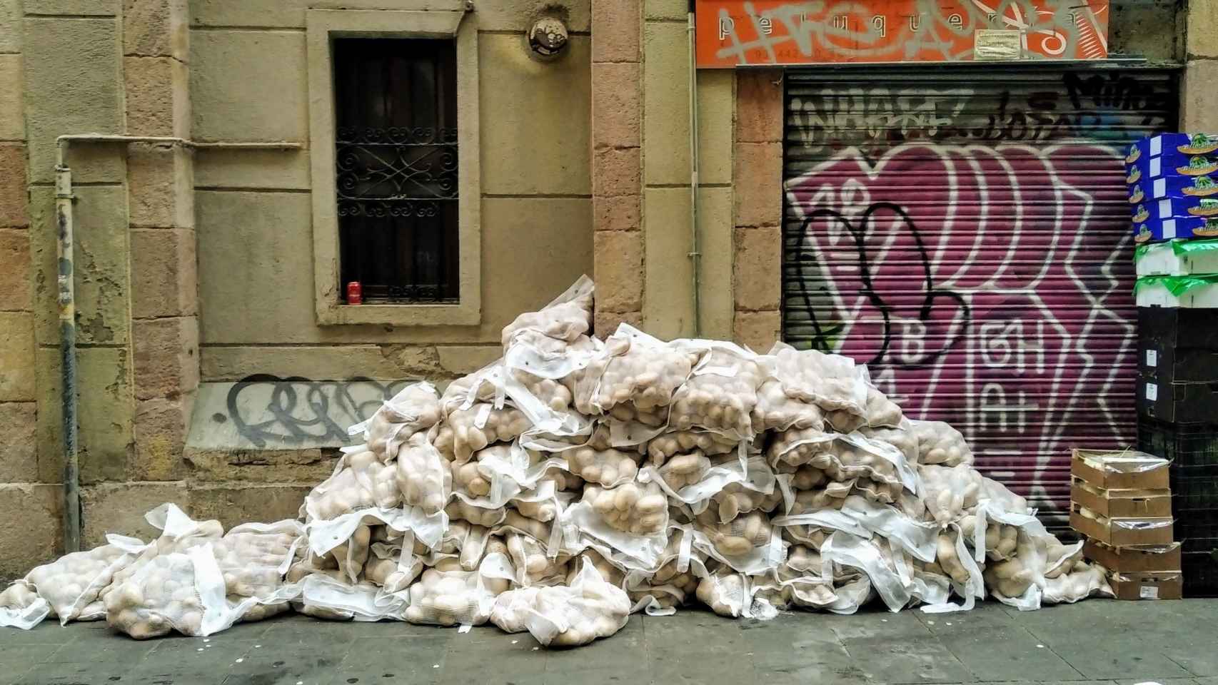Sacos de patatas acumulados en la calle de Guifré del Raval / TWITTER - @rafagomo