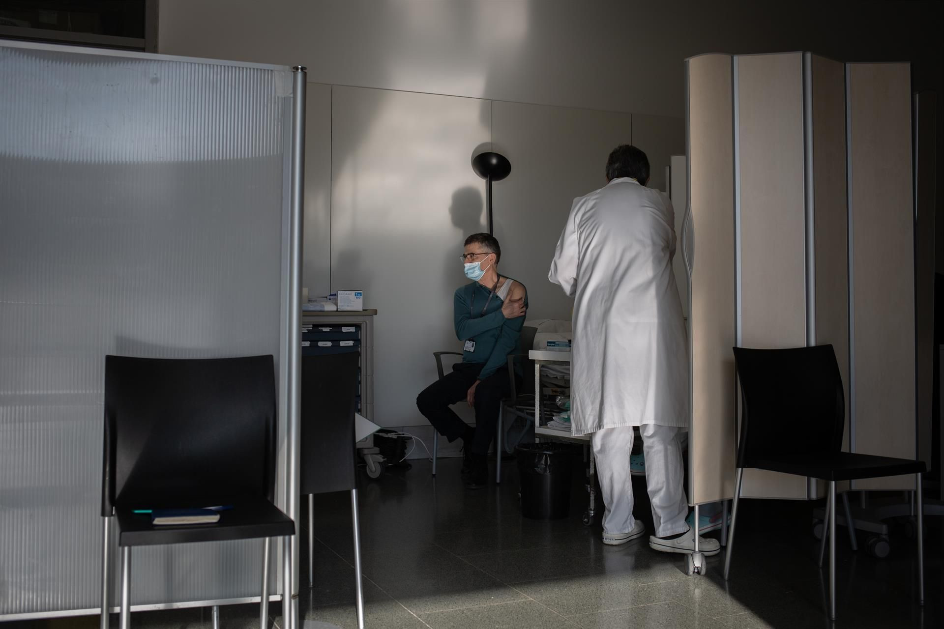 Una enfermera vacuna a un profesional sanitario con la vacuna de Pfizer-BioNtech contra el COVID-19 en el Hospital de la Santa Creu i Sant Pau de Barcelona / David Zorrakino - Europa Press